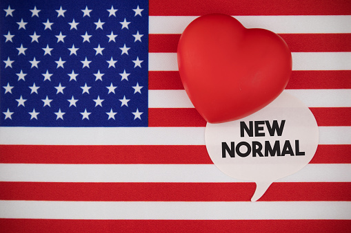 New Normal After Coronavirus. New Normal speech bubble note paper on the USA Flag. Horizontal composition with copy space. Global Health and COVID-19 pandemic concept.