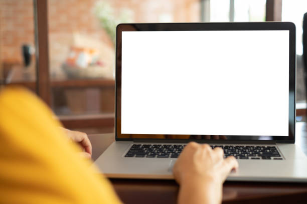 women using laptop computer Mockup image of woman using and typing laptop computer with blank white desktop screen working at home. laptop stock pictures, royalty-free photos & images