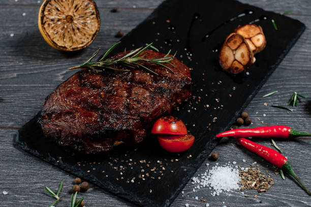 istock huge juicy steak meat on black plate on grey served table. traditional dish menu served in a restaurant 1222162575