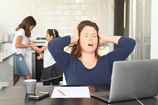 upset mother working from home while children fight in the background - anger furious mother adult imagens e fotografias de stock