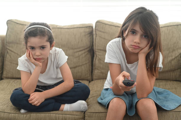 скучные девушки смотрят на экран телевизора - family television fighting watching стоковые фото и изображения