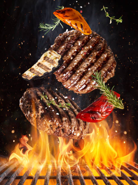 istock Tasty beef steaks flying above cast iron grate with fire flames. 1222164455