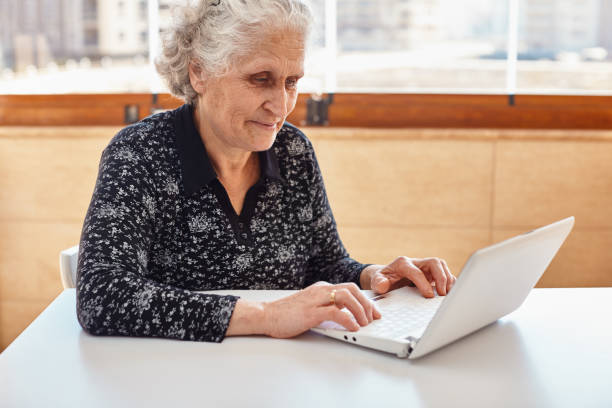 istock Beautiful elderly woman with white hair using a laptop computer on desk 1222167406