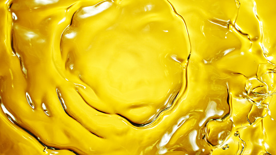 Macro shot of Splashing Oil on Golden Background