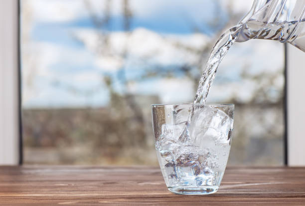 istock water pouring from jug into glass 1222168813