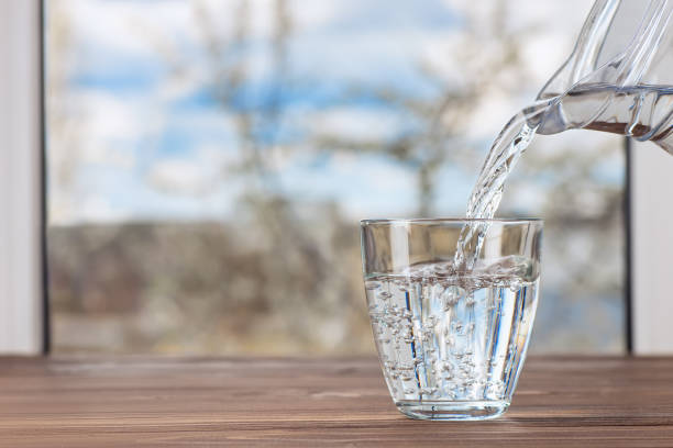 istock water pouring from jug into glass 1222168827