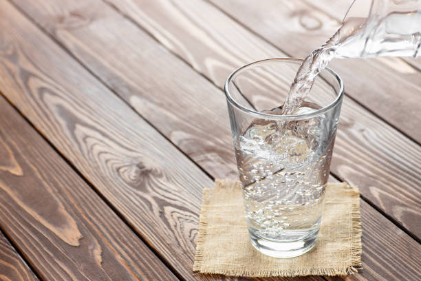 istock water pouring from jug into glass 1222168834