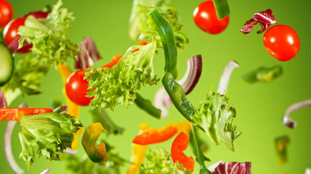 istock Flying vegetable salad isolated on green background. 1222169636