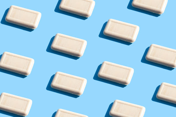 istock Pattern of pieces of solid soap on a blue background with trendy sunlight. Wash your hands. Soap against bacteria and viruses. Compliance with hygiene and sterility to combat coronavirus. 1222169763