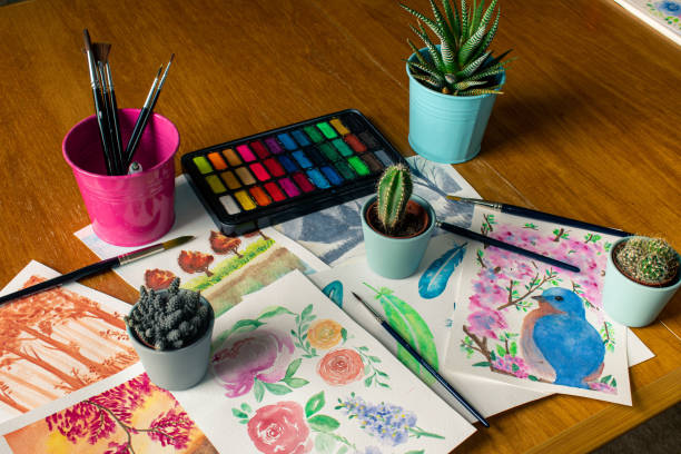 istock Watercolor palette and brushes with some canvases and three cactuses 1222172399