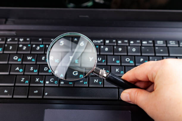 istock Hand with magnifier on a laptop background. 1222174012