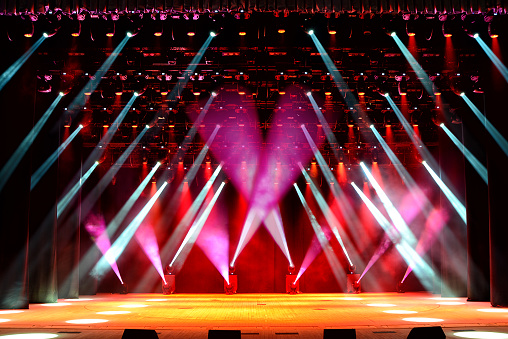 Illuminated empty show stage with red light beams and stage fog