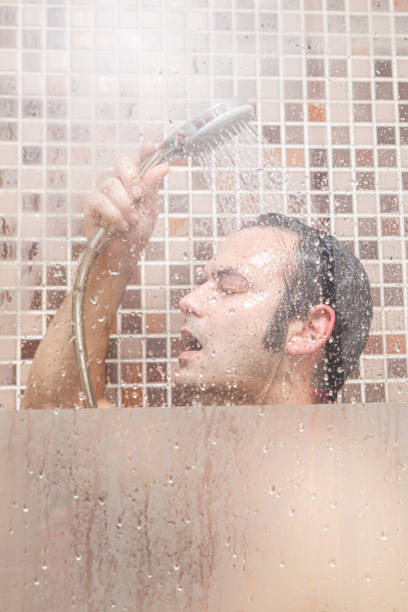 istock Young Caucasian man, showering behind glass with drops. 1222179098