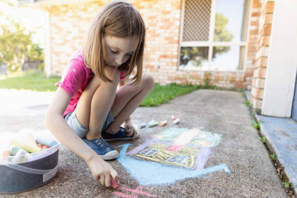istock Young Girl Doing Chalk Art On Driveway 1222180580