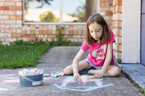 istock Young Girl Doing Chalk Art On Driveway 1222180633