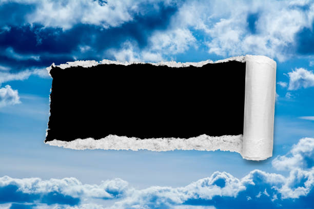 A hole in the day sky with torn edges, as on paper, with an isolated black copyspace background in the center. The concept of global climate change on Earth, global warming, a hole in space and time. un agujero en el cielo del día con bordes rotos, como en papel, con un fondo de espacio de copia negro aislado en el centro. el concepto de cambio climático global en la tierra, el calentamiento global, un agujero en el espacio y el tiempo.