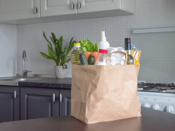 istock Safe home delivery. A package with products such as milk, eggs, vegetables and wine in a modern kitchen 1222182981