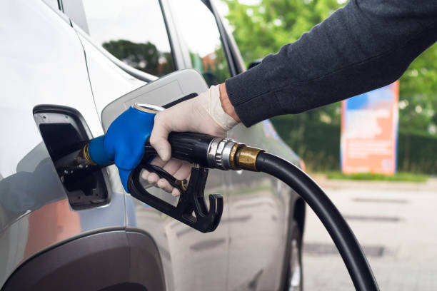 istock Man refueling car wearing protective gloves to prevent infections. 1222183164