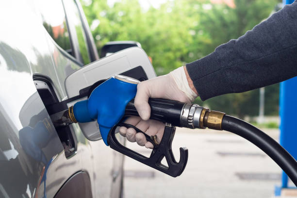 istock Man refueling car wearing protective gloves to prevent infections. 1222183186