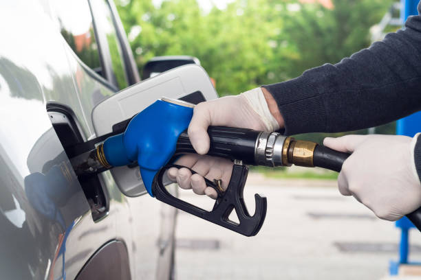 istock Man refueling car wearing protective gloves to prevent infections. 1222183191