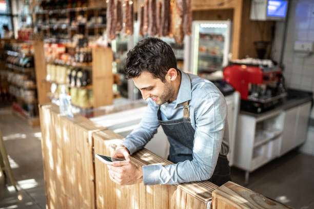 istock Small business owner using mobile phone at his store 1222184617