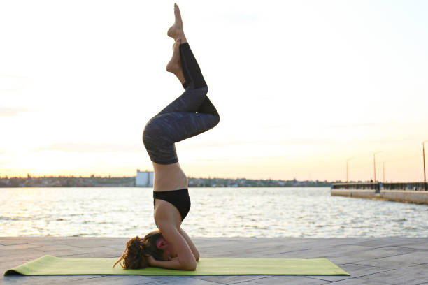 istock Female yoga instructor stretching on the green mat. 1222184780