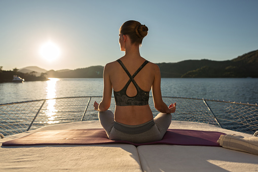 Sunset Yoga on the Yacht. Meditation and Yoga Practicing at Sunset