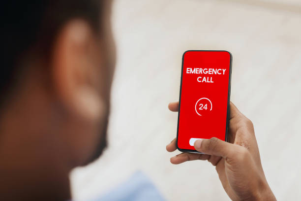 istock Black man holding smart phone with emergency number 1222185939