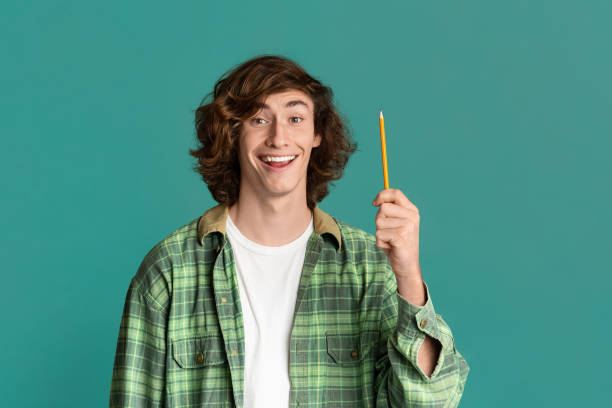 istock Having idea. Young guy pointing up pencil on color background 1222186490