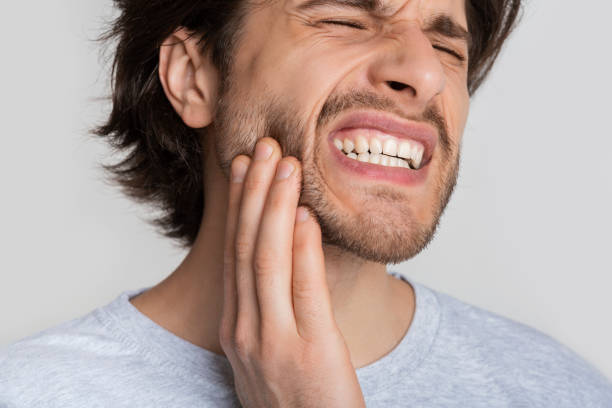 istock Toothache concept. Man is grimaces from pain 1222186615
