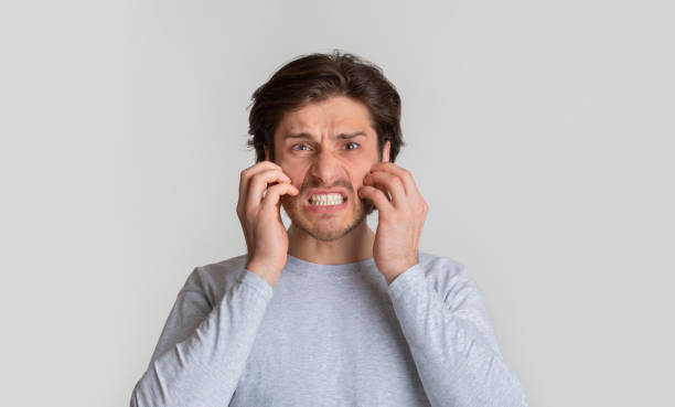 istock Allergy concept. Millennial man scratches his cheeks 1222186707