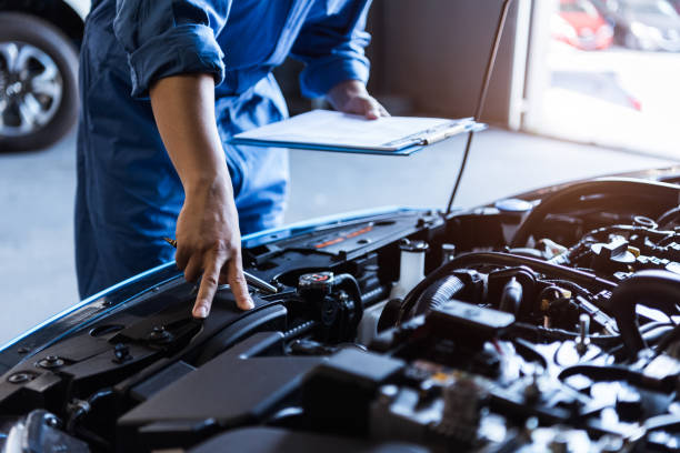 mecánico de coches sosteniendo portapapeles y comprobando el vehículo de mantenimiento por pedido de reclamo del cliente en el garaje del taller de reparación de automóviles. servicio de reparación del motor. ocupación de personas y trabajo de negoci - maintenance engineer industry asian ethnicity technology fotografías e imágenes de stock