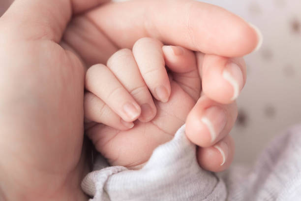 istock newborn baby hand in mother's hand 1222189018