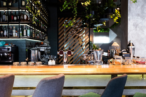 Bar counter with soft chairs in cafe with no visitors, luxury alcohol drinks, copy space