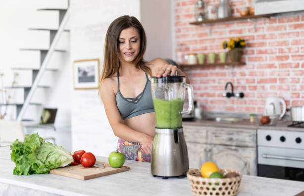 istock Smiling sporty woman making smoothie 1222189419