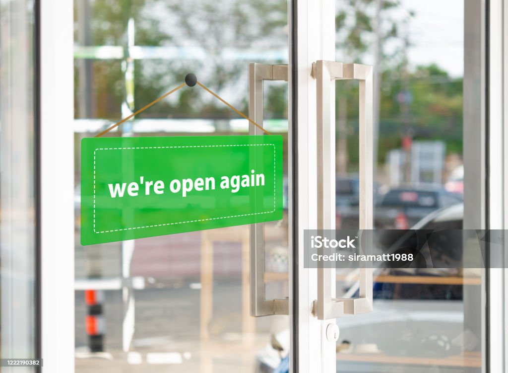 The green label has the message that "we're open again" on the entrance door. Open Sign Stock Photo