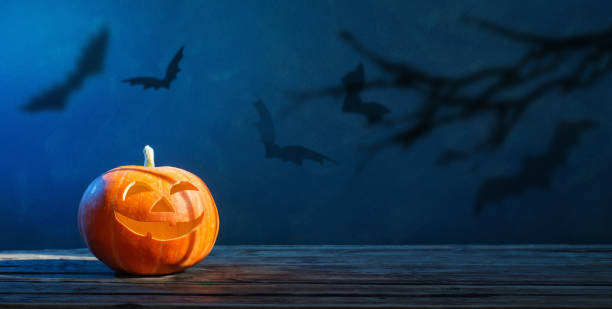 calabaza de halloween sobre fondo azul oscuro - octubre fotos fotografías e imágenes de stock