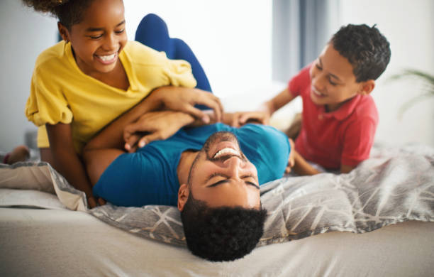 playing with dad is the best. - offspring child lying on back parent imagens e fotografias de stock