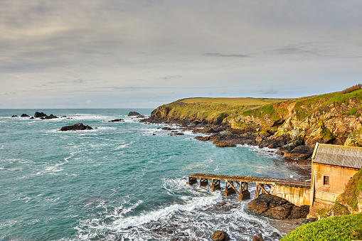 Image of the bay and former life boat station at Lizard Point, Cornwall, with an overcast sky.