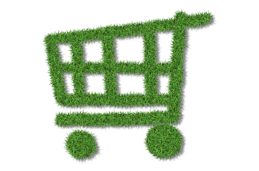 Shopping Cart in lush green grass on a white background