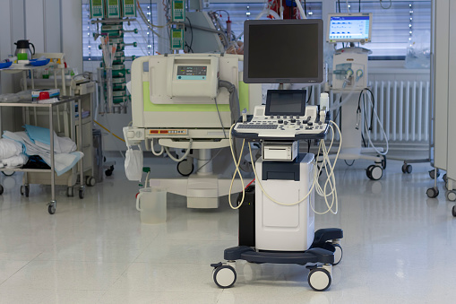Ultrasound machine, on background patient connected to medical ventilator and dialysis machine . Place where can be treated patients with pneumonia caused by coronavirus covid-19