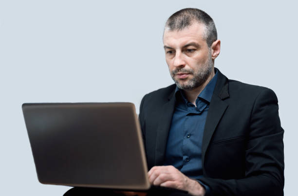 istock Businessman Working On Laptop Sitting Over Gray Studio Background 1222193274