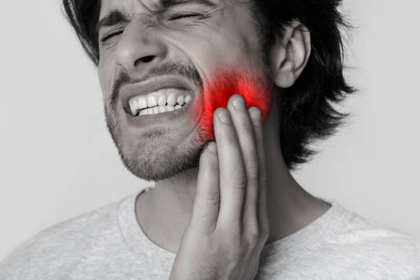 istock Man presses hand to cheek, highlighted in red 1222194185
