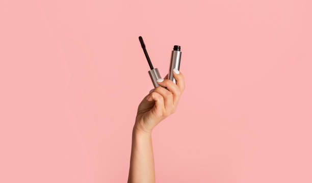 Beauty and makeup. Young girl holding mascara on pink background, close up Beauty and makeup concept. Young girl holding mascara on pink background, close up eyelash photos stock pictures, royalty-free photos & images