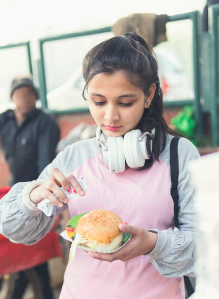 Girl eating street food with enjoying.
