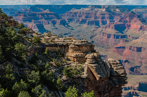 A group of hikers is standing on a steep cliff watching the sun set over famous Grand Canyon in summer, Grand Canyon National Park, Arizona, USA,Nikon D3x