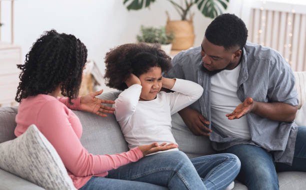 Family Upbringing. Little girl covering ears not to listen parents scolding Family Upbringing Concept. Small african kid girl covering ears not to listen parents scolding, disobedient child ignoring father's words man closing ears photos stock pictures, royalty-free photos & images