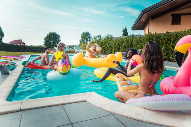 istock Friends having fun in a swimming pool 1222198407