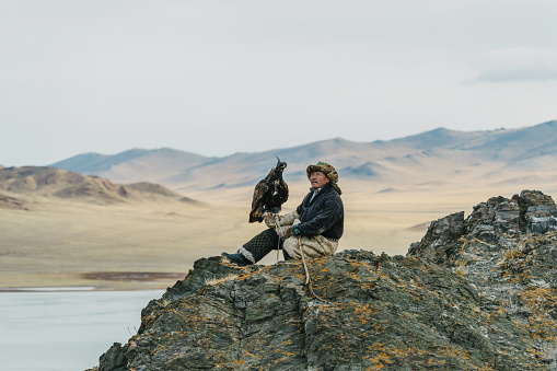Eagle hunter on the background of lake in Gobi desert in Mongolia