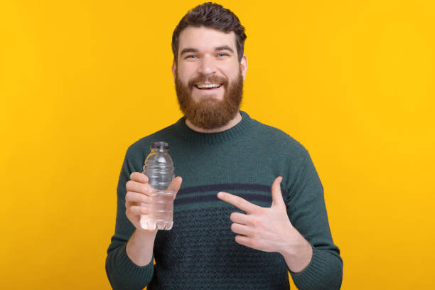 istock Smiling man is saying do not forget to hydrate and drink water. 1222199828